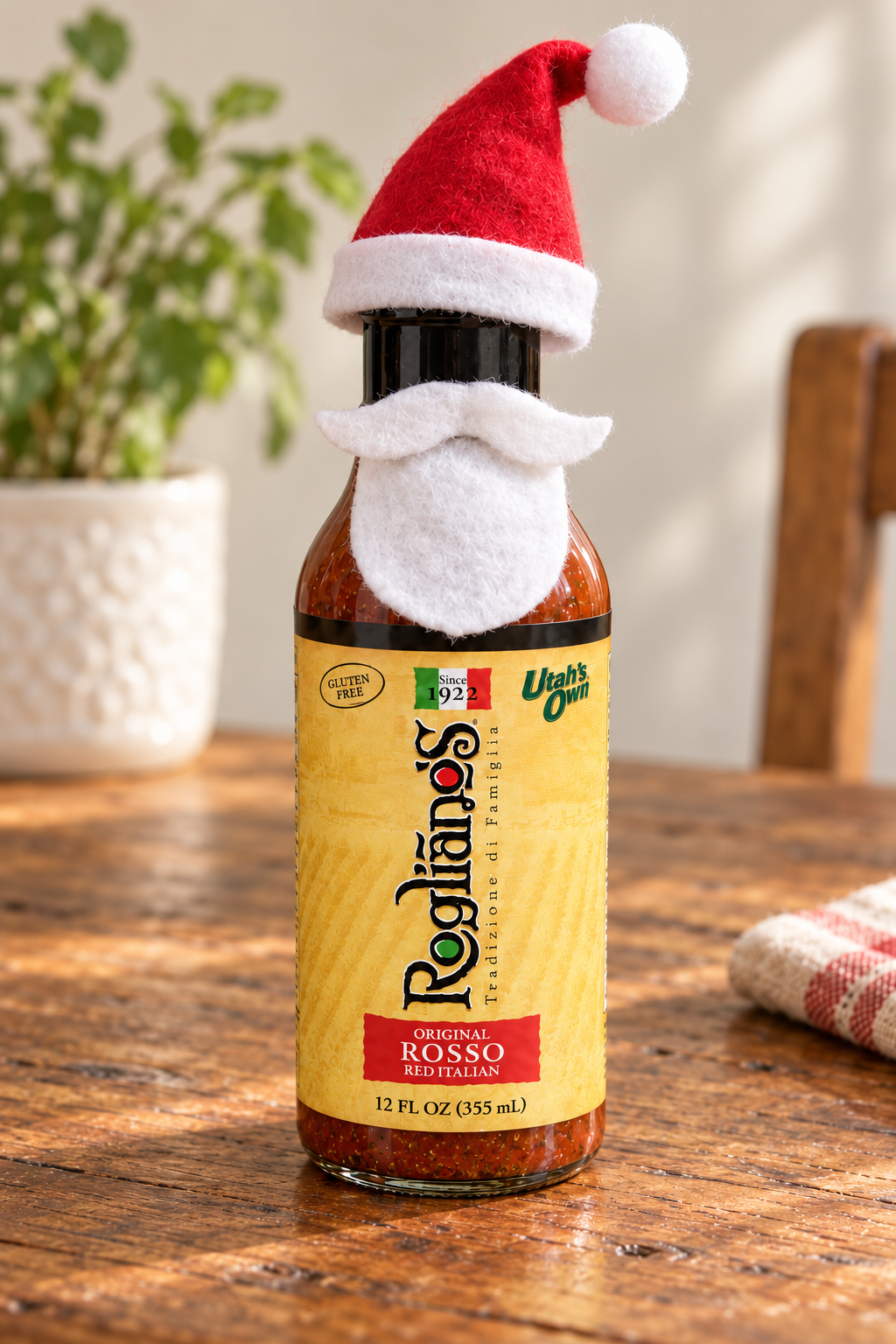 A Rosso bottle dressed as Santa with a red felt hat, white brim and pom-pom, and a white felt beard and moustache.